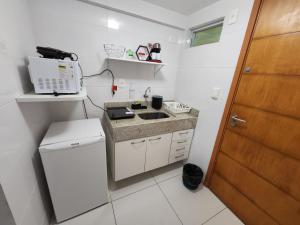 una pequeña cocina con fregadero y microondas en Israel Flat da Mar & Sol, en João Pessoa