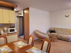 a kitchen and a living room with a table at Apartament 7 Bystrzycka - Bliżej Zdroju in Polanica-Zdrój