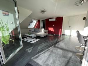 ein Wohnzimmer mit einem weißen Sofa und einer roten Wand in der Unterkunft Exklusive Wohnung mit Ahrblick 1 und Dachterrasse in Bad Neuenahr-Ahrweiler