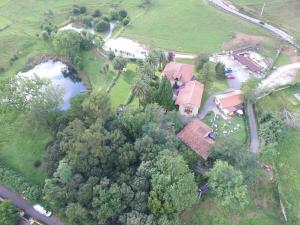 an aerial view of a house with trees and a pond at Casona Dos Lagos in Villanueva