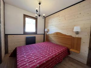 a bedroom with a red bed in a wooden wall at Appartement Lanslevillard, 3 pièces, 6 personnes - FR-1-508-26 in Lanslevillard