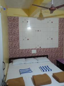 a bed with two pillows on it in a room at Ambai Deluxe Lodge in Kolhapur