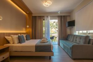 a hotel room with a bed and a couch at Nicole Studios in Agia Effimia