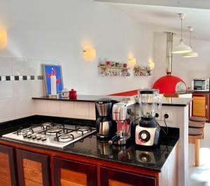 a kitchen with a stove and a blender on a counter at Bangalô de Madeira em Condomínio de Praia in Camaçari