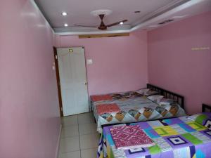 1 dormitorio con 2 camas y ventilador de techo en Ambai Deluxe Lodge, en Kolhapur