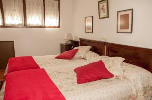 a bedroom with two beds with red pillows at Miyares casa rural in Miyares +5 photos