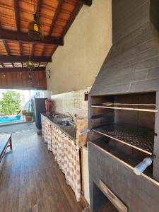 a kitchen with a large grill and a sink at Pousada Luz de Candeia in São João Batista do Glória