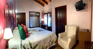 1 dormitorio con 1 cama, 1 silla y TV en Hotel Doña Sancha en Covarrubias