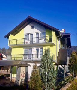 a yellow and white house with a balcony at Apartment Studenac in Pale