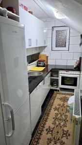 a kitchen with white cabinets and a refrigerator at Apartment Studenac in Pale