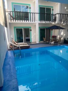 a large blue swimming pool with a house at Hotel Caracol Isla Mujeres in Isla Mujeres