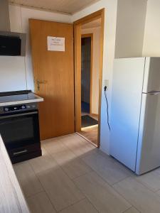 a kitchen with a refrigerator and a door to a hallway at Ferienwohnung Siegen Eiserfeld 2 in Siegen
