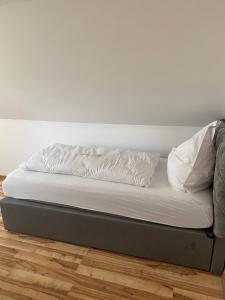 a bed with white sheets and pillows on it at Ferienwohnung Siegen Eiserfeld 2 in Siegen