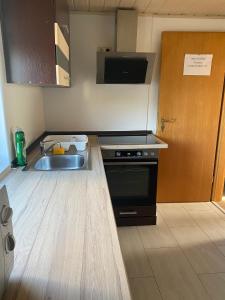 a kitchen with a sink and a stove at Ferienwohnung Siegen Eiserfeld 2 in Siegen