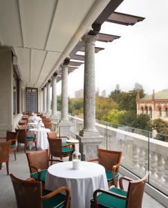 una fila di tavoli e sedie su un balcone di Casa Cipriani Milano a Milano