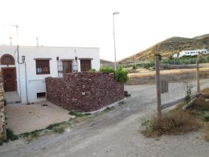 ein Gebäude mit einer Steinmauer neben einer unbefestigten Straße in der Unterkunft Casa Juan Gil in Almería