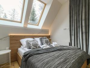 een slaapkamer met een bed en 2 ramen bij VisitZakopane- Toscana Apartment in Zakopane