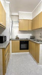 a kitchen with wooden cabinets and a dishwasher at The Appartment in Llança