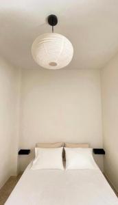 a bedroom with a white bed and a light fixture at The Appartment in Llança