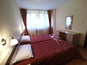 a hotel room with a bed with a stuffed animal on it at Ski Area @ Apartment Rosea 205 @ Pamporovo in Pamporovo