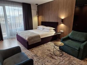 una camera d'albergo con letto, divano e sedia di AMA by Melis a Braşov