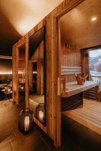 a room with wooden walls and a large mirror at ALMMONTE PRÄCLARUM SUITES Design Hotel in Wagrain
