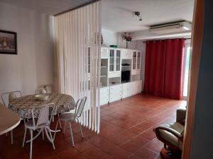 een keuken en eetkamer met een tafel en stoelen bij Albufeira INN - Casa dos Aveiros - Dolamar 4A T1 in Albufeira