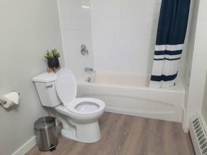 a bathroom with a toilet and a bath tub with a plant at Modern Suite in Historic Bldg. Minutes to DT in Calgary