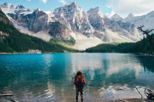 une femme debout devant un lac avec des montagnes dans l'établissement Modern Suite in Historic Bldg. Minutes to DT, à Calgary