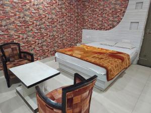 um quarto com uma cama, uma mesa e cadeiras em Golden Park Inn em Jarmundi