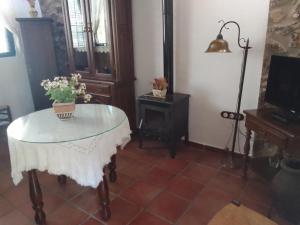 Habitación con mesa de cristal y lámpara. en Alojamiento Rural El Campito, en Zafra