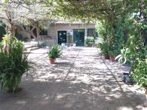 eine Terrasse mit Stühlen und Bäumen sowie ein Gebäude in der Unterkunft Alojamiento Rural El Campito in Zafra