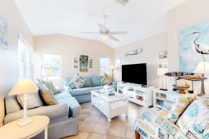 a living room with a couch and a tv at Sea's The Day in Anna Maria