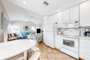 a kitchen with white appliances and a white table at Sea's The Day in Anna Maria