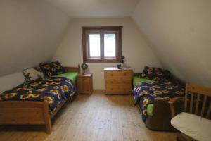 a attic bedroom with two beds and a window at Chata Terasa Kubinska in Dolný Kubín