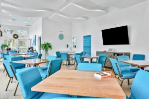 邁爾斯堡的住宿－Fort Myers Fantasy，餐厅设有蓝色的桌椅和平面电视。