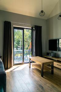 uma sala de estar com uma mesa e uma porta de vidro deslizante em Hortensja em Wilków