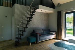 a living room with a couch and a spiral staircase at Hortensja in Wilków