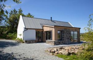 a house with a metal roof and a garage at Finnan's Byre in Edinbane
