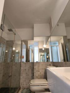 y baño con aseo, lavabo y espejos. en Edificio Kennedy, en Punta del Este