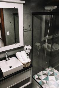 a bathroom with a sink and a shower at Pousada Refúgio do Vale - Praia do Rosa in Praia do Rosa +22 photos