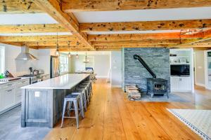 a kitchen with a stone fireplace and a stove at Pet-Friendly House with Deck - 10 Mi to Stowe Mtn! in Stowe
