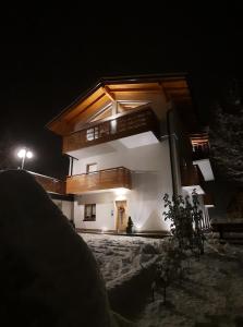 uma casa à noite com as luzes acesas em Il giardino di Anna em Fai della Paganella