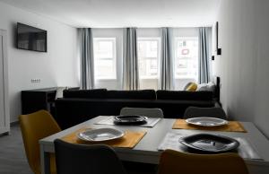 ein Wohnzimmer mit einem Tisch, Stühlen und einem Sofa in der Unterkunft Almada Downtown 202 in Porto