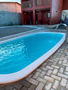una piscina con una fuente de agua en Chale c churrasqueira a 5 min da Praia de Pipa RN, en Pipa