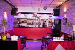 a bar with two tables and a red wall at MyRoomz Silver Strand Hotel in Blackpool
