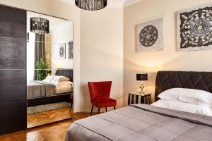1 dormitorio con cama, silla y espejo en PragueOne Apartment,A/C,Terrace, en Praga