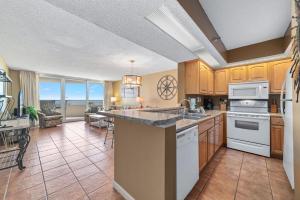 a kitchen with wooden cabinets and a living room at Perdido Sun 212 in Perdido Key