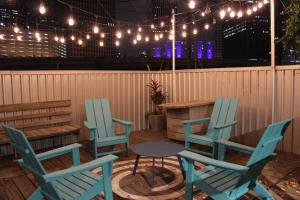 a patio with blue chairs and a table and lights at Midtown/Downtown-Luxury2BR+Patio-Heart of City in Houston