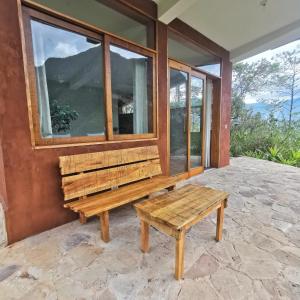 Goctamarca Lodge في Cocachimba: مقعد خشبي وطاولة على شرفة